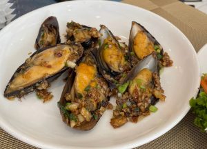 Garlic-infused mussels on a white plate