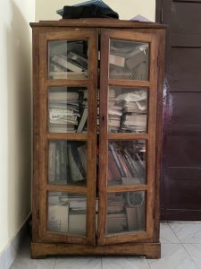 An old cupboard filled with books.
