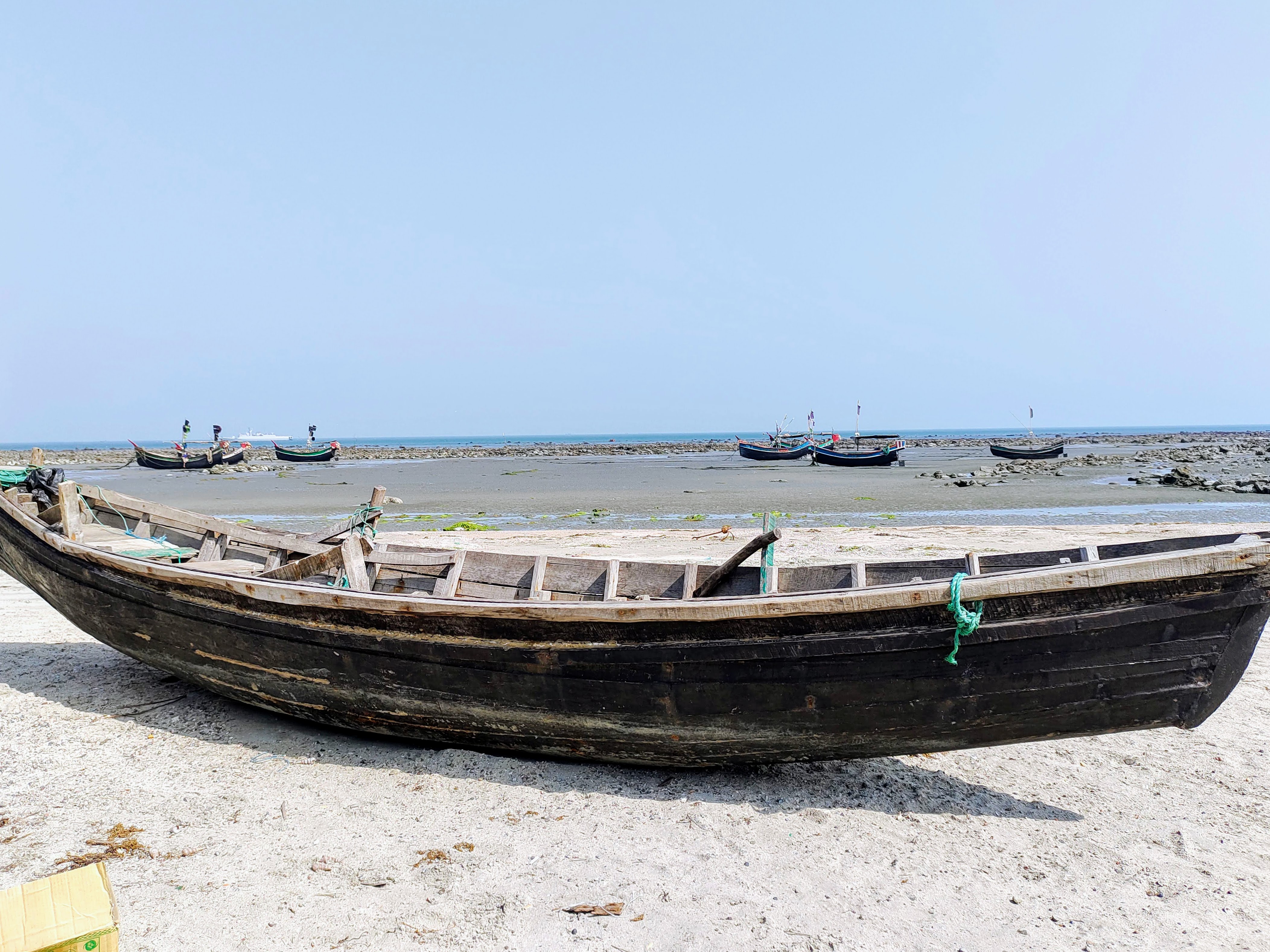 A boat sitting on a sandy beach