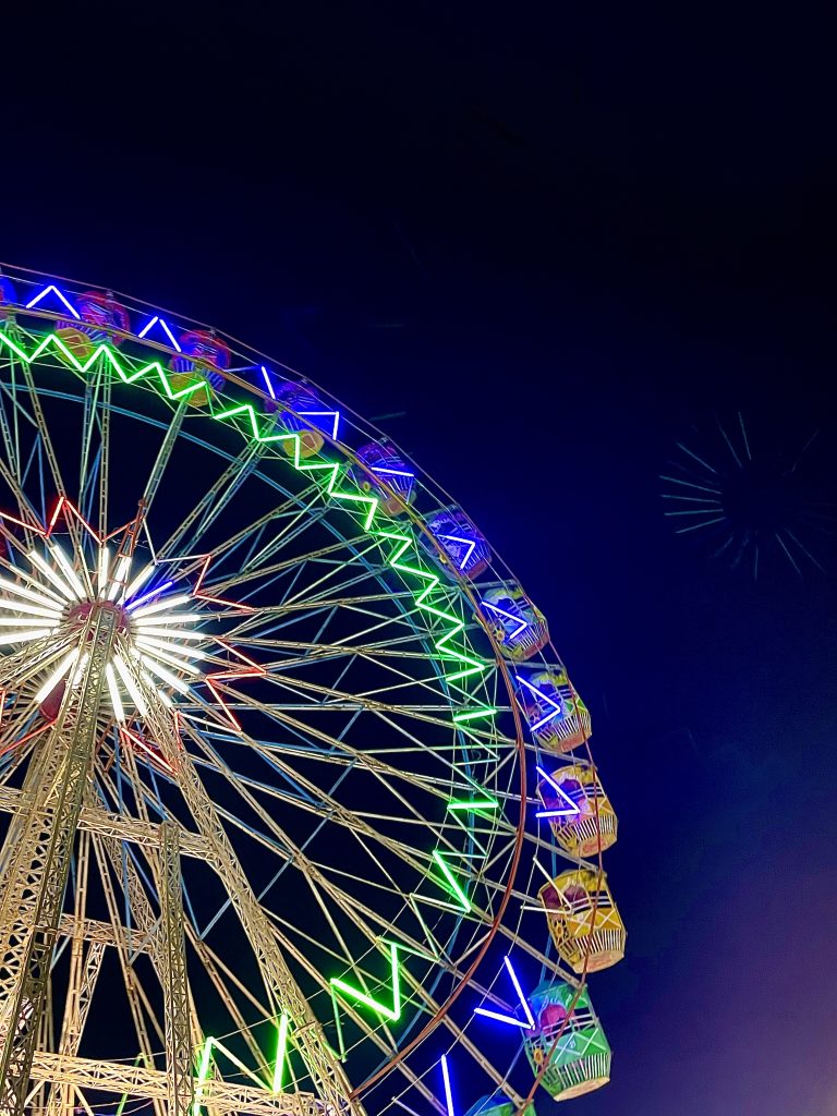 An illuminated giant ferris wheel during the night.