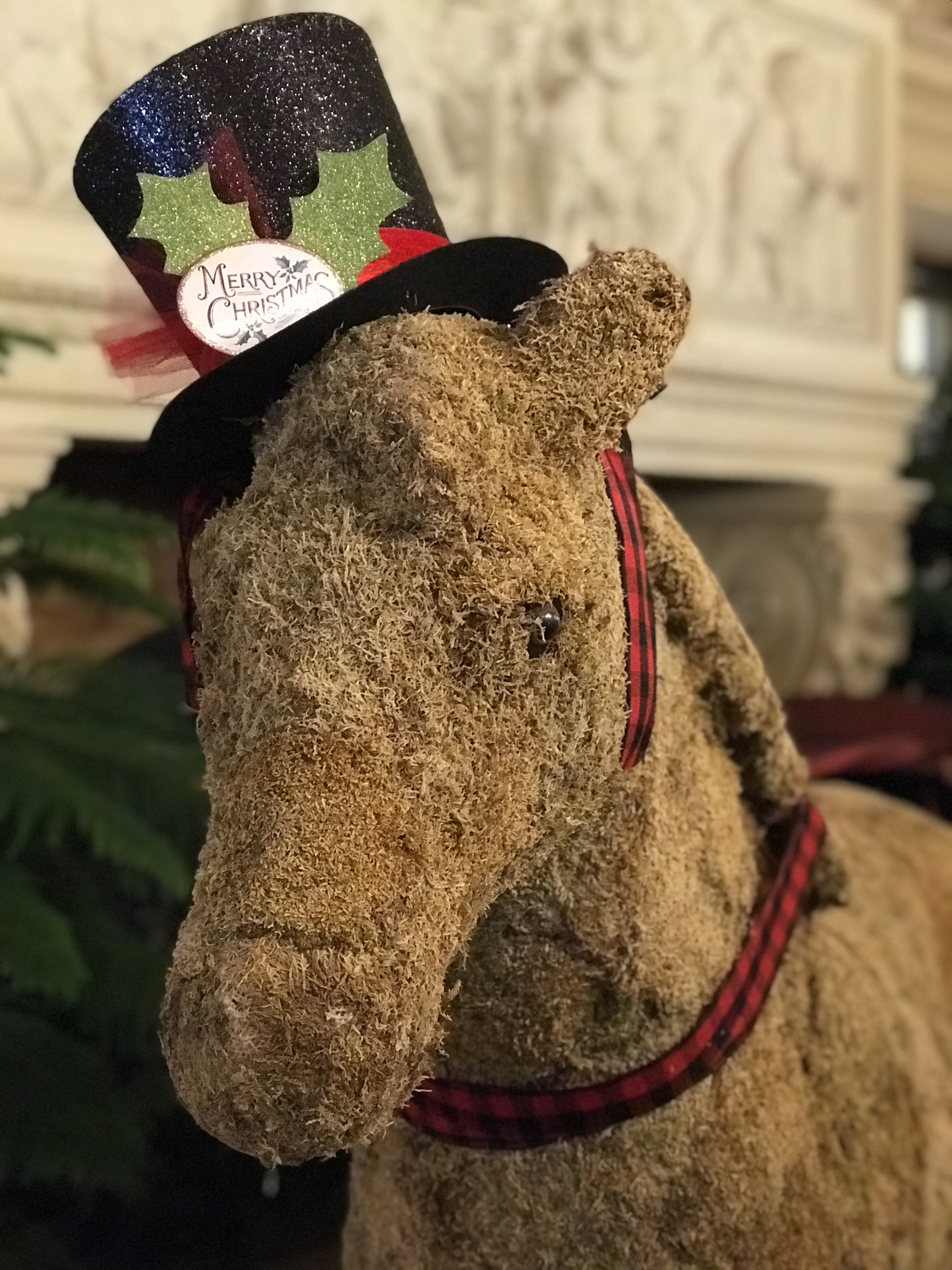 A decorative horse made from Spanish moss wearing a black top hat that says "Merry Christmas" at The Breakers mansion in Newport, Rhode Island.