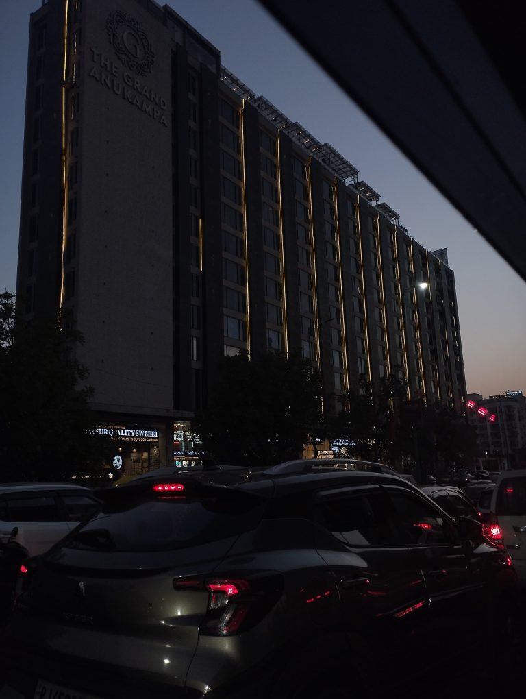 Cars and a building under the twilight sky.