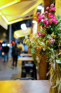 Purple flower bouquet at a restaurant table in the street.