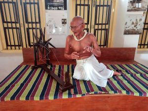 Statue of Mahatma Gandhi weaving cotton on charkha
