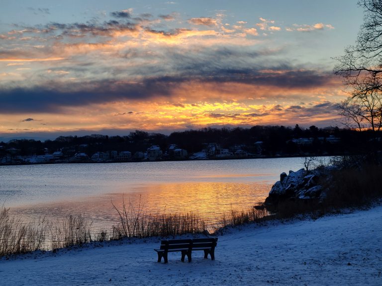 Sunrise reflecting on to water, beside snow covered ground, Marblehead from Forest River Park, Salem MA