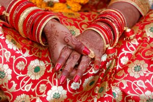 A bride's hand adorned with intricate mehendi art, symbolizing a marriage ceremony.