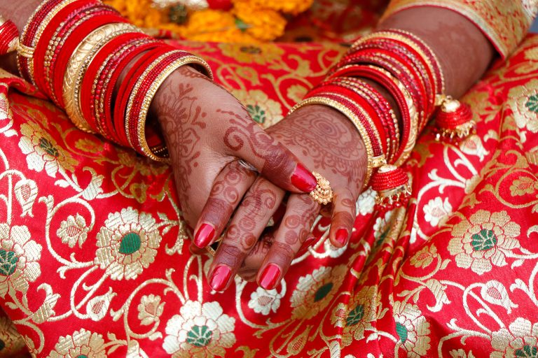 A bride’s hand adorned with intricate mehendi art, symbolizing a marriage ceremony.