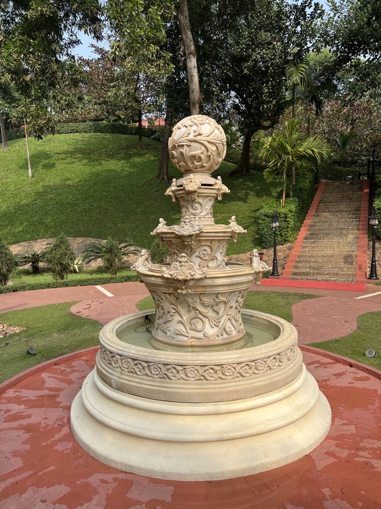 A serene park scene featuring a marble fountain, tree, creating a peaceful ambiance