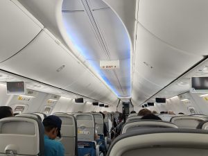 The inside of an airplane with people sitting on the seats.