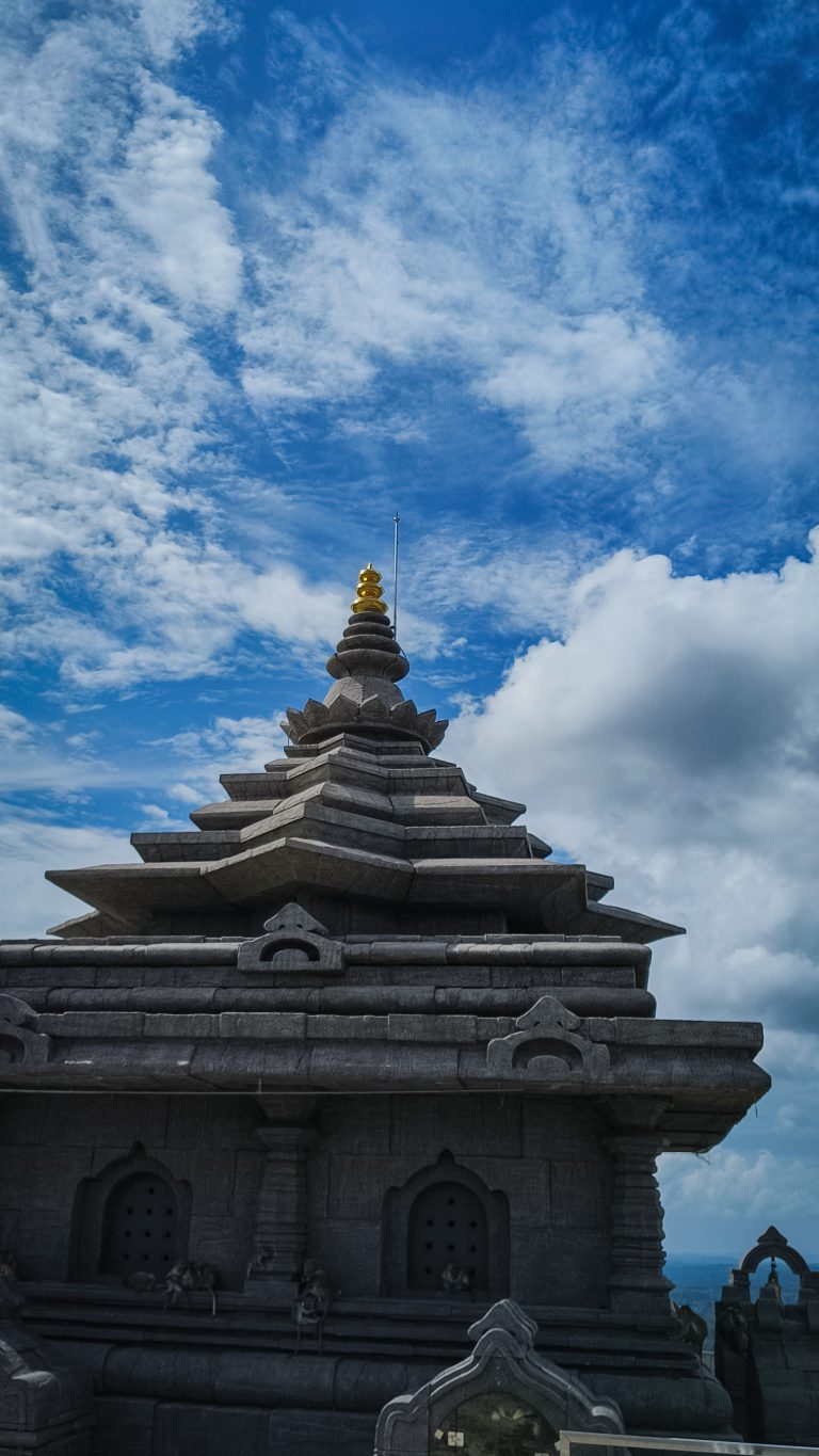 A historical Temple on the top of a mountain on the background of blue sky and monkeys on temple walls