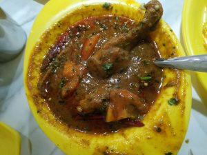 Chicken Handi in a yellow bowl with a spoon