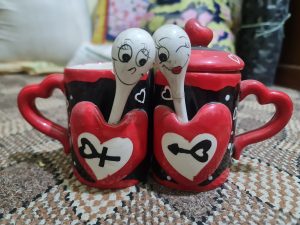 Pair of tea cups with spoons, featuring a combination of red and white colors.