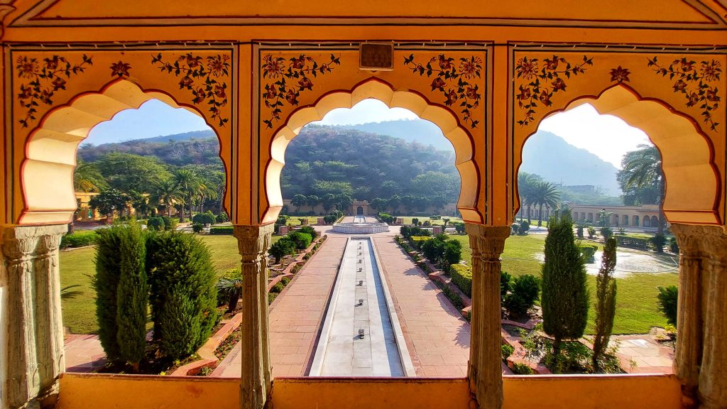 View of Sisodia Rani ka Bagh garden via three yellow arches having designs of flower and leaf paintings. Photo taken from Jaipur, India.