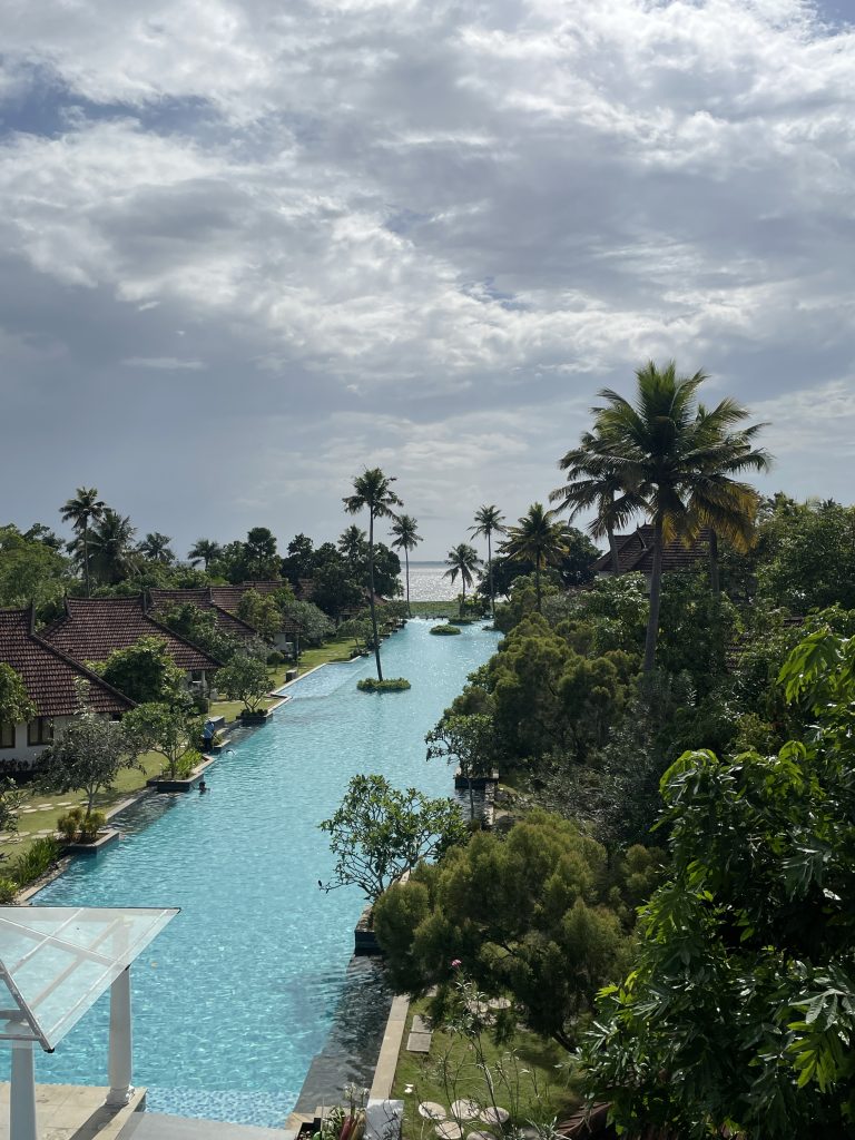 A swimming pool with a view of the lake and sky full of clouds.