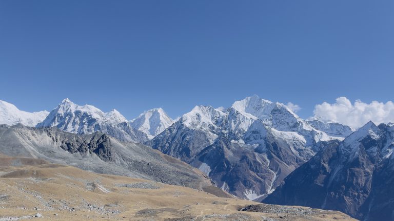 The Himalayas, visible from Langtang, present a mesmerizing scene against the backdrop of a clear and azure sky.