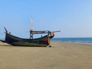 An abandoned ship on Saint martin sea beach in Bangladesh with the water in the background
