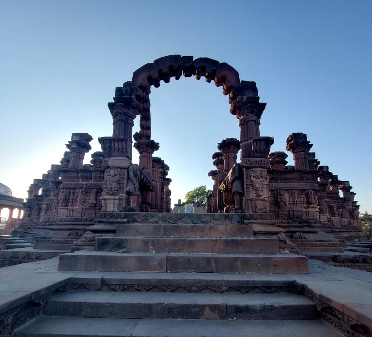 Chhatedi Bhuj. Ancient ruins with ornate pillars, arches, and steps against a blue sky.