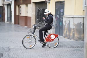 Tourist looking for directions on he phone while sitting on a public rental bicycle