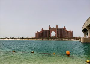 A captivating perspective of Atlantis, The Palm in Dubai, captured from the opposite side of the beach, showcasing its grandeur against the stunning backdrop of the coastline.