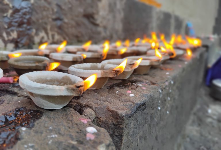 Countless lamps illuminated on a ledge for the festival of Tripurari Purnima.