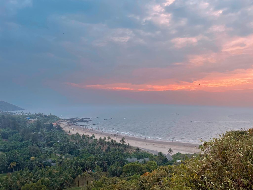 A pink sky as the sun sets over a beach