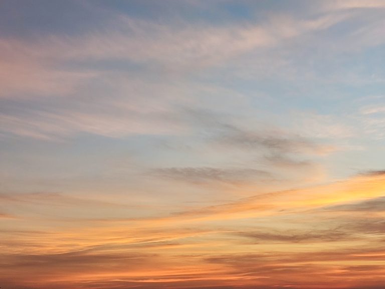 Cirrus clouds glowing orange during sunset