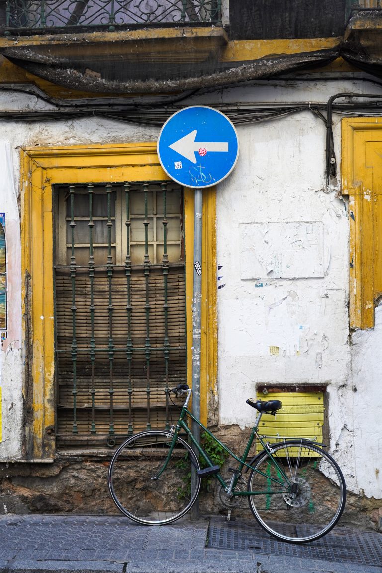 Green bicycle parked in front of a very old building.