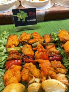 View larger photo: Skewers of crocodile meat on a market stand