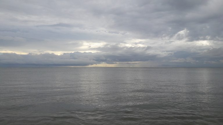 A grey sky over a calm sea