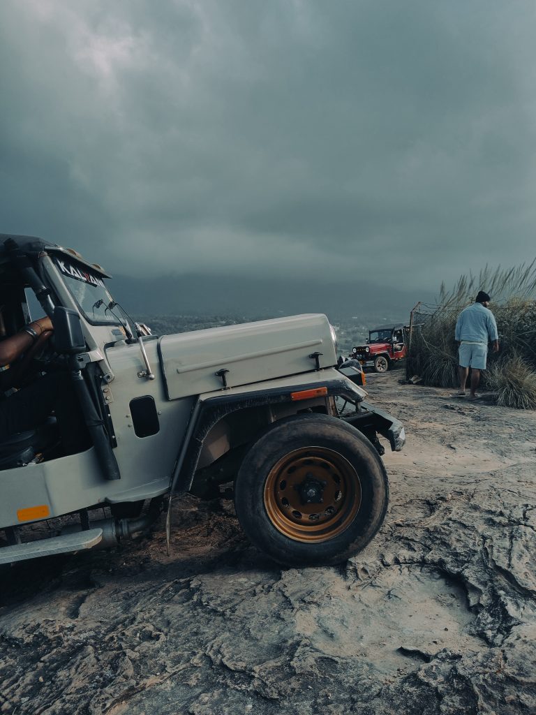 Jeeps trekking on mountain top on a cloudy day.