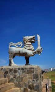 The lion holding a sword statue in the Galle Face Beach in Sri Lanka with a background having a blue sky.