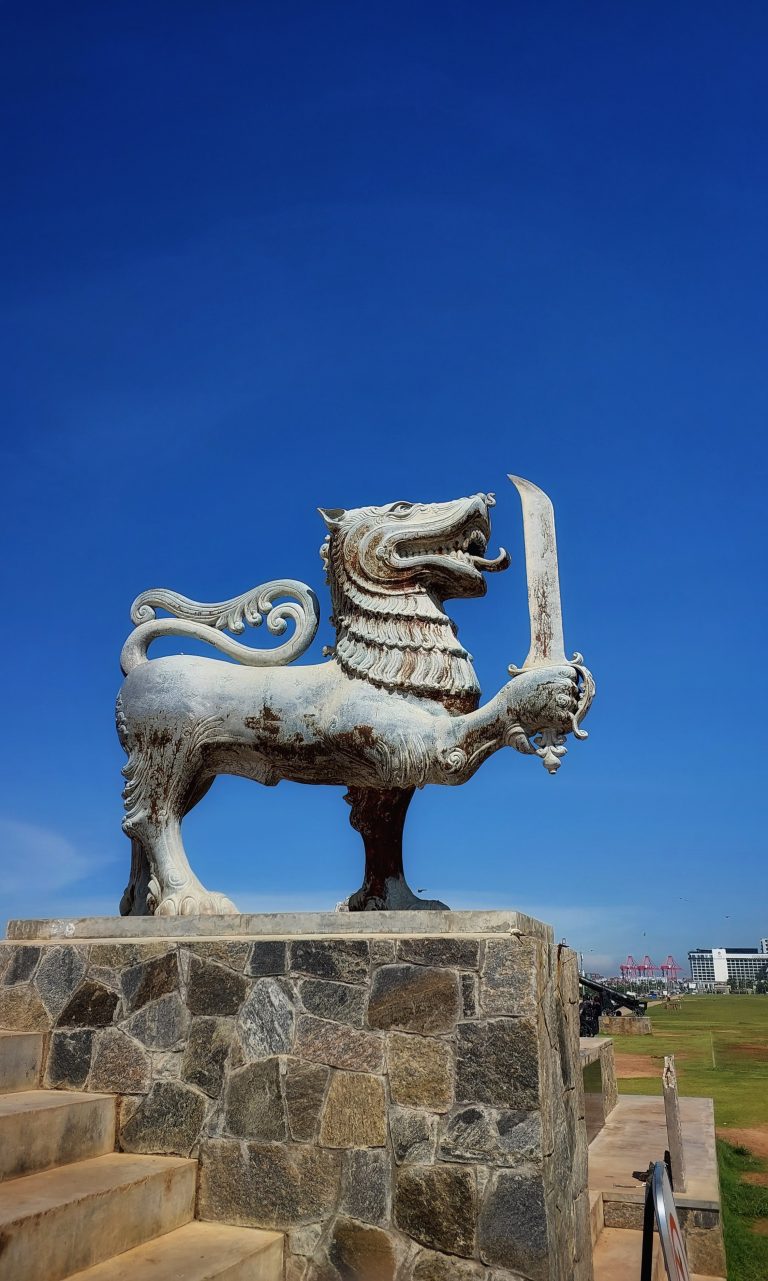 The lion holding a sword statue in the Galle Face Beach in Sri Lanka with a background having a blue sky.