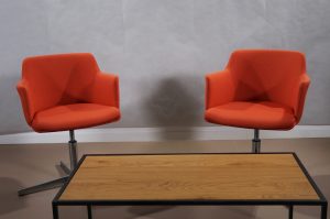 Televisión set with two orange couches with a coffee table, ready for an interview