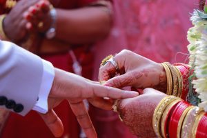 The engaged couple is exchanging rings during their wedding ceremony.