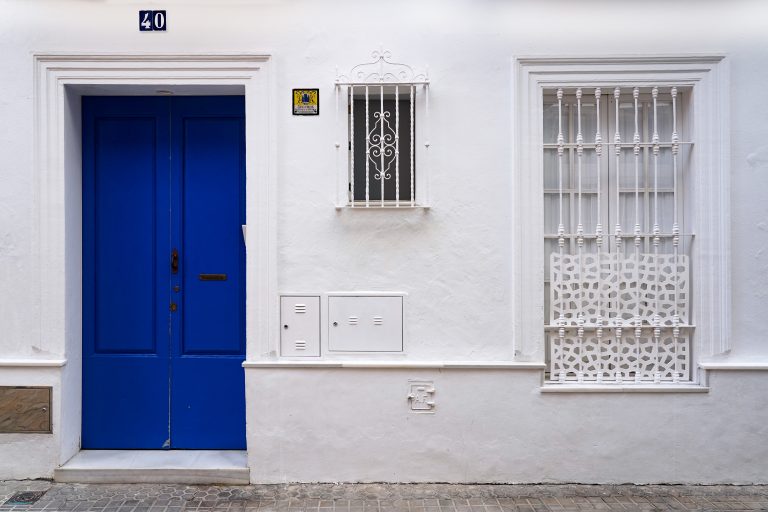 Very white house with a very blue door