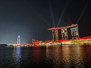 A night view of Marina Bay, Singapore with lighting illuminating the surroundings.
