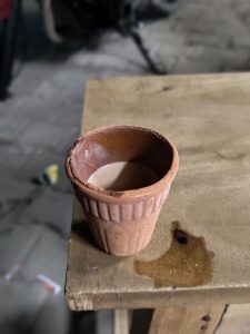 Tea in a Kulhad, a soil-made glass, atop a stool, showcasing cultural elegance and eco-friendly aesthetics in a minimalist composition.