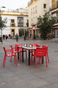 Table and red chairs from a bar in the street 