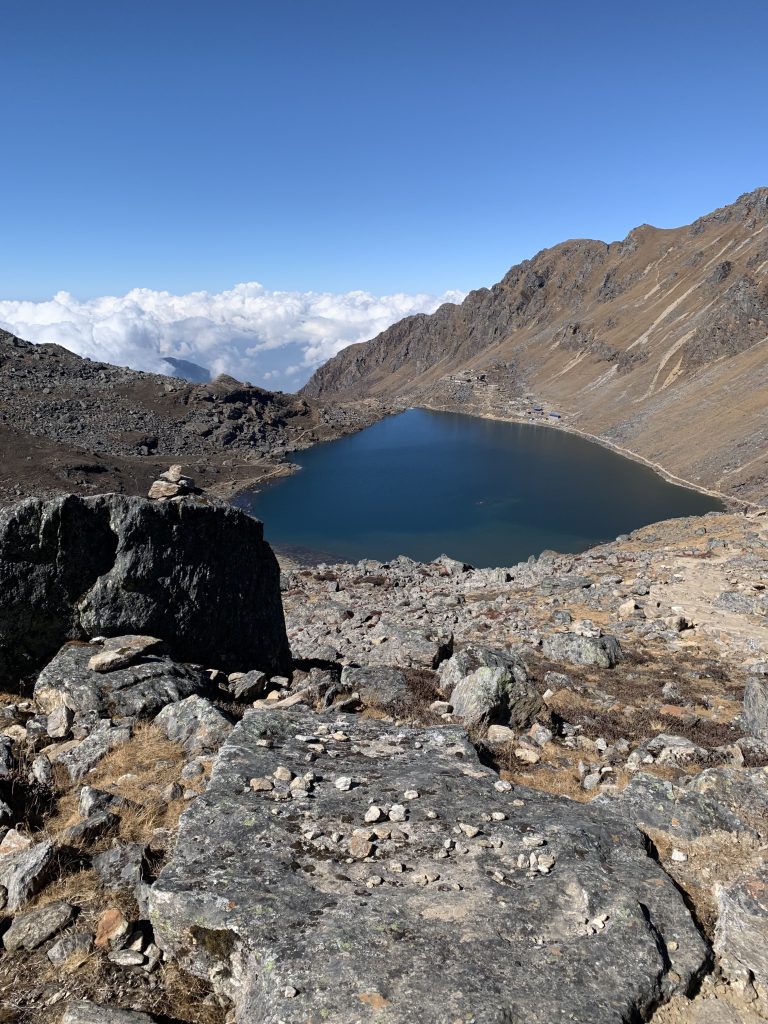 Lake surrounded by rock and dirt hills within a mountain