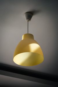 Sunlight is hitting the yellow ceiling lamp.