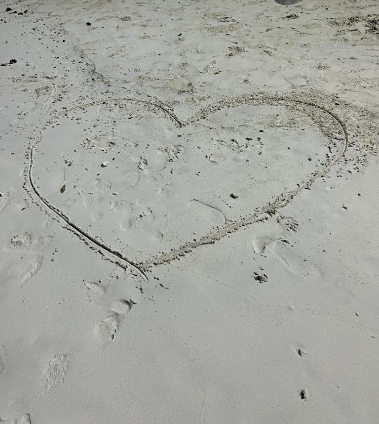 A heart drawin into the sand on a beach