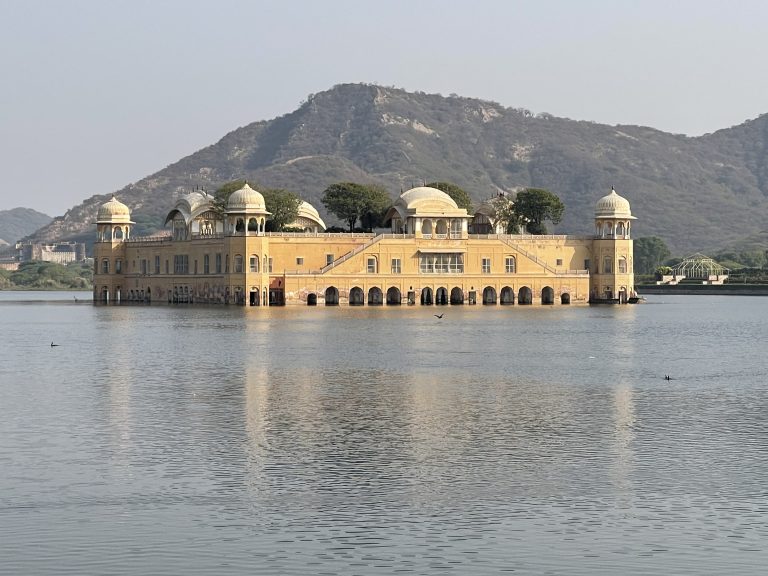 The Water Palace stands as a masterpiece of architectural harmony, with its golden walls and domes mirroring the tranquility of the surrounding waters and hills.