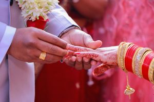 The engaged couple is exchanging rings during their wedding ceremony.