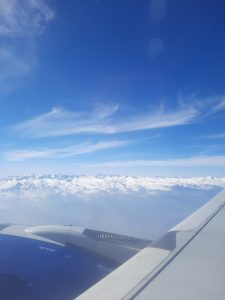 View larger photo: Looking out of an airplane at snow covered mountains