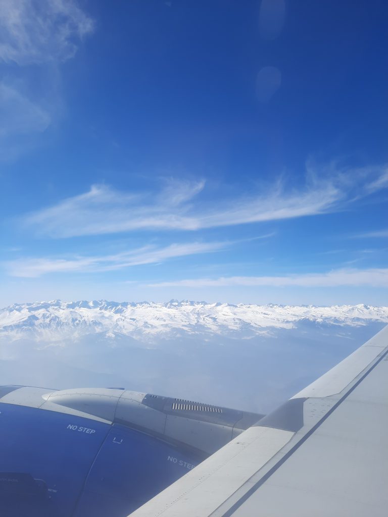 Looking out of an airplane at snow covered mountains