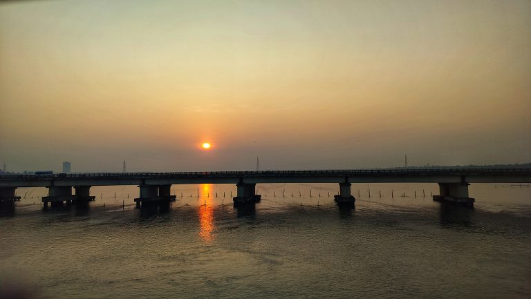 The sunrise over a bridge and water