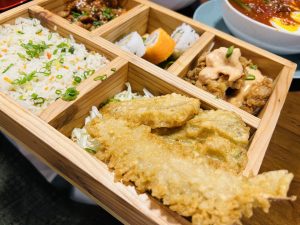 View larger photo: A wooden tray filled with a variety of delicious food items.