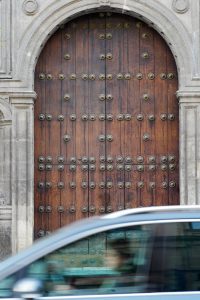 Car passing the wooden door of a church