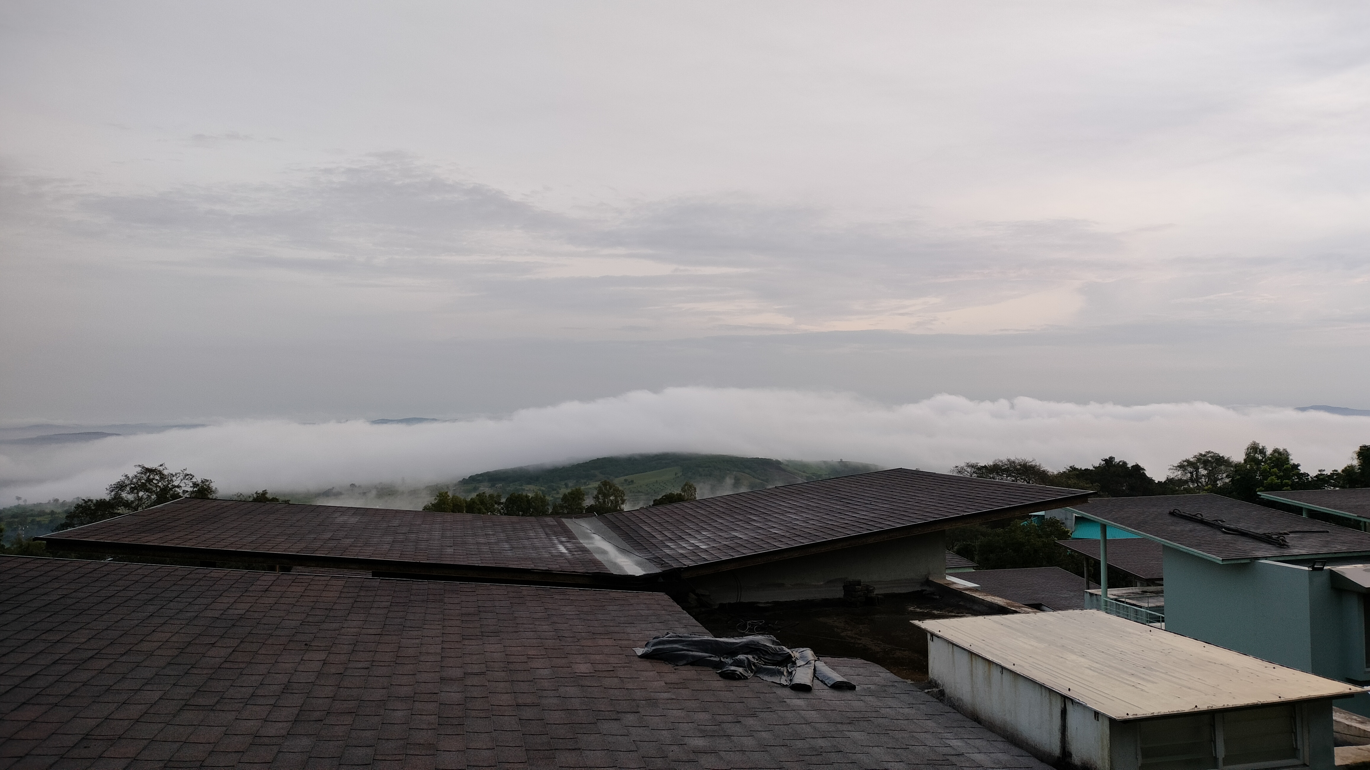 Clouds gracefully drift above the village, enhancing the beauty of the rainy season.