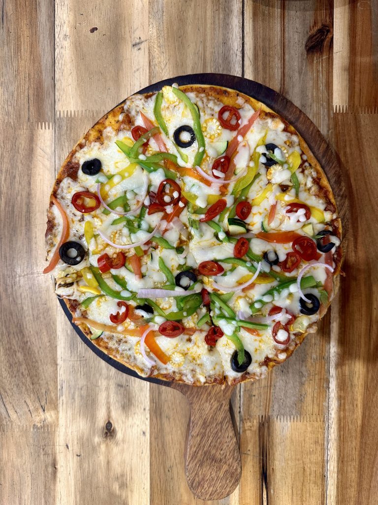 A delicious pizza served on a rustic wooden table.